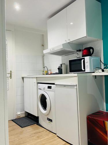 une cuisine avec un lave-linge et un micro-ondes dans l'établissement Paris Arts et Métiers, à Paris