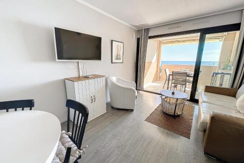un salon avec un canapé, une télévision et une table dans l'établissement Le Panorama - Seafront - Swimming pool - Car park, à Cannes