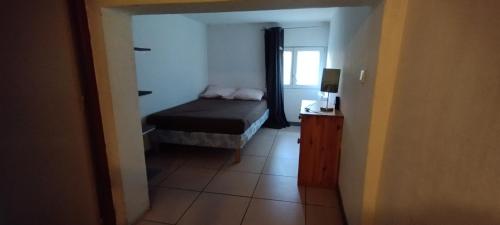 une petite chambre avec un lit et une fenêtre dans l'établissement Montreuil en duplex, à Montreuil