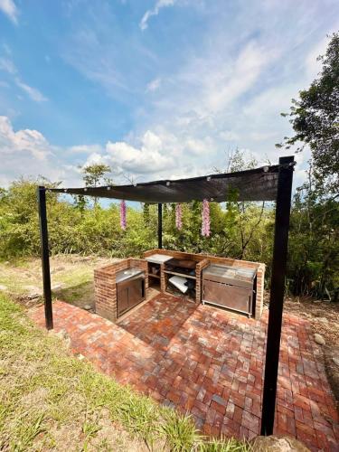 a pavilion with a picnic table in a field at Finca Anapoima completa - Villa Paty - Piscina privada in Anapoima