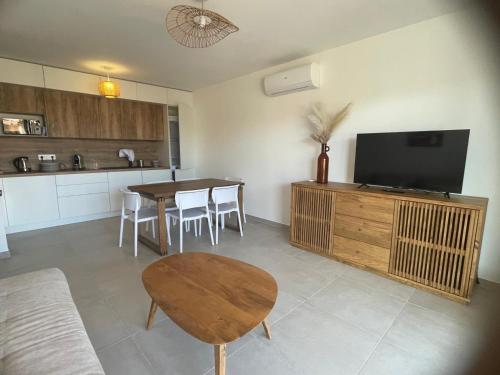 Il comprend une cuisine et un salon avec une table et une télévision. dans l'établissement Apartment 2 Favone, South Corsica, beach 100m away, à Conca