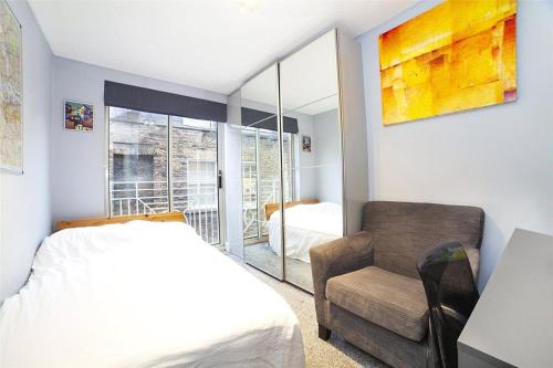a bedroom with a bed and a chair and a window at Seven Dials, Covent Garden - a one-minute walk to Soho - see full details in my profile below in London