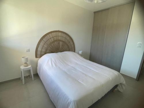 - une chambre avec un grand lit blanc et une table de chevet dans l'établissement Apartment 2 Favone, South Corsica, beach 100m away, à Conca
