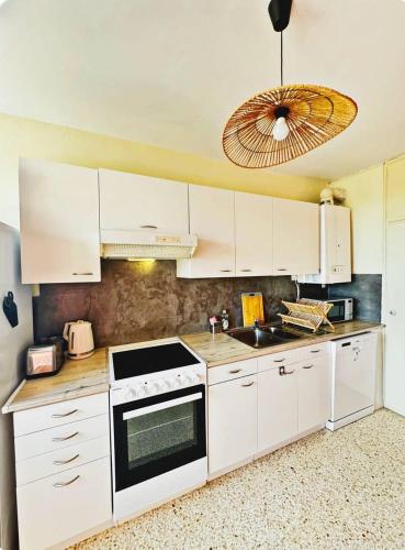 une cuisine avec des armoires blanches et un four à plaques de cuisson dans l'établissement magnifique appartement