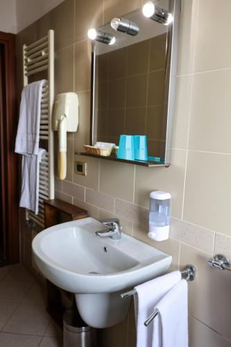 a bathroom with a sink and a mirror and towels at Hotel Erbaluce in Caluso