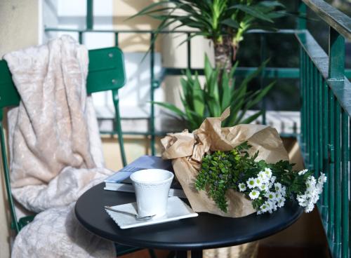 a table with a paper bag and flowers on it at Savi Guest House metro B S Paolo in Rome