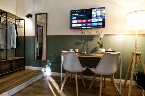 a desk with two chairs and a computer monitor on the wall at Savi Guest House metro B S Paolo in Rome
