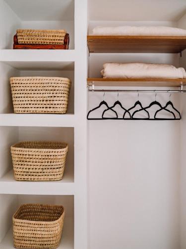 a walk in closet with baskets and towels at Tamraght Bleu House in Tamraght Oufella