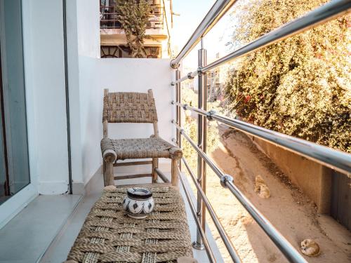 a chair sitting on the balcony of a building at Tamraght Bleu House in Tamraght Oufella
