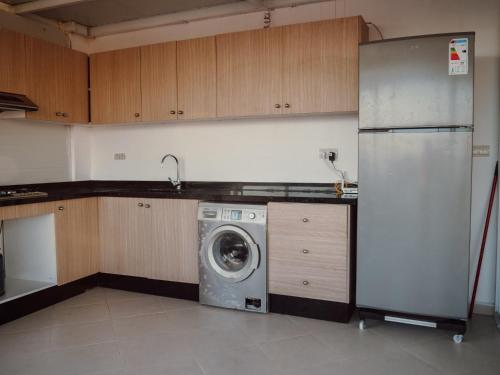 a kitchen with a refrigerator and a washing machine at Tamraght Bleu House in Tamraght Oufella