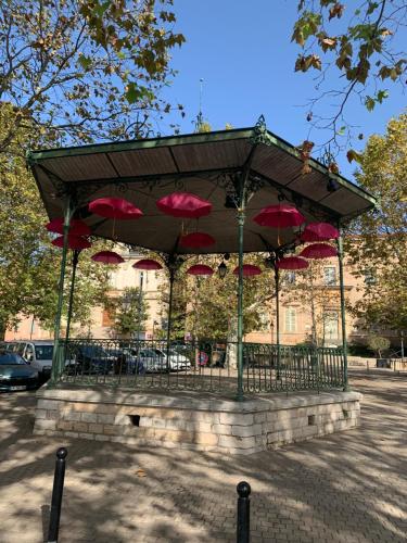 a gazebo with red umbrellas on it at La Nichée appartement 2 chambres in Trévoux
