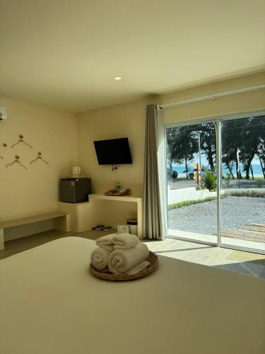 a bedroom with a bed with a tv and a window at Sunvada Beach Rayong in Rayong