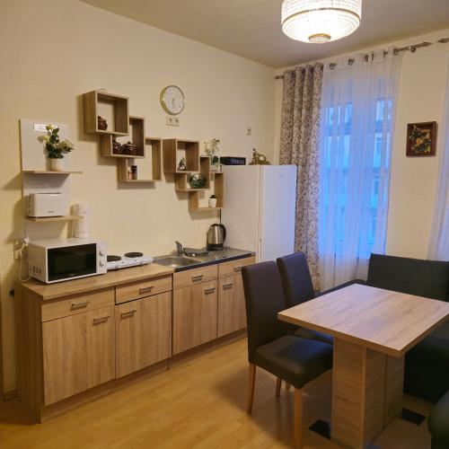 a small kitchen with a table and a refrigerator at Apartment 5 in Gera