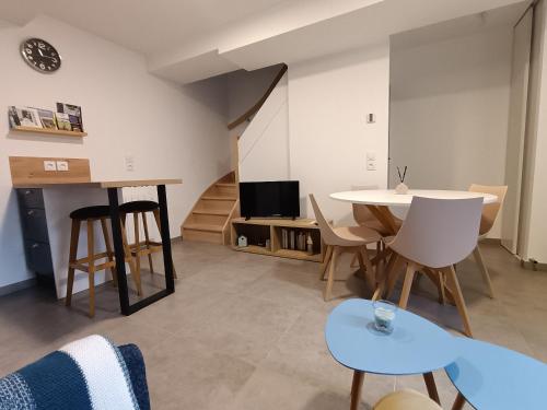 a living room with a table and a tv at Duplex Moderne de 33m2 - Elegance et Confort in Doudeville