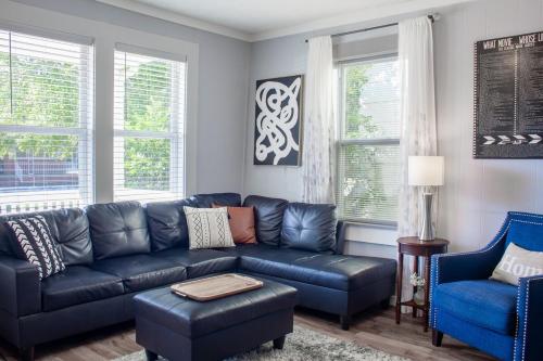 a living room with a black leather couch and blue chairs at Bungalow 7- Downtown, cozy, comfortable in Wilmington