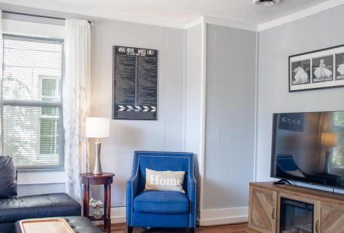 a living room with a blue chair and a tv at Bungalow 7- Downtown, cozy, comfortable in Wilmington