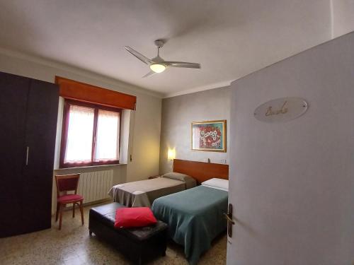 a bedroom with two beds and a ceiling fan at Hotel Signorini in Castiglioncello