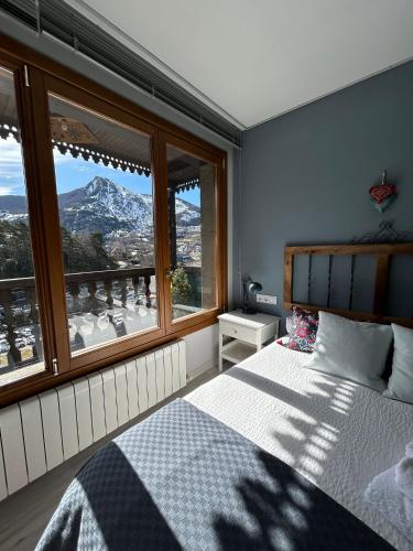 a bedroom with a bed with a view of a mountain at El Balcón del Garmo in Sallent de Gállego