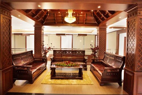 a large living room with leather couches and a table at Athirappilly Residency Chalakudy in Kizhake Chālakudi