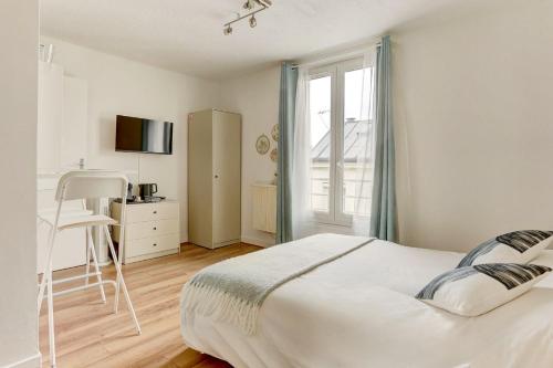 une chambre avec un lit, un bureau et une fenêtre dans l'établissement Le Courcillon Calme, Cour privée & Proche Château, à Versailles