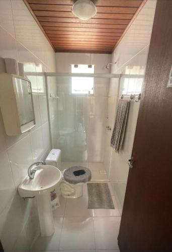 a bathroom with a shower and a sink and a toilet at Casa de campo in Itapema
