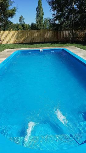a large blue swimming pool in a yard at Cabaña con tinaja más hidromasaje in Temuco