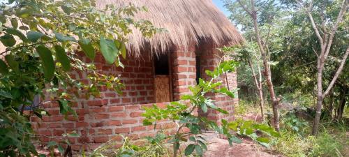 Tongwe Cultural Heritage Center في Katumbi: مبنى من الطوب القديم مع سقف من القش