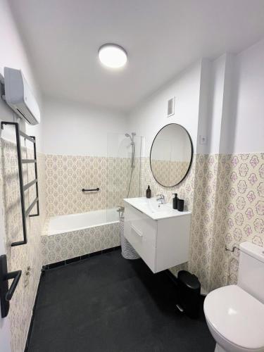 une salle de bain avec un lavabo, une baignoire et des toilettes dans l'établissement bel appartement proche plage, au Lavandou