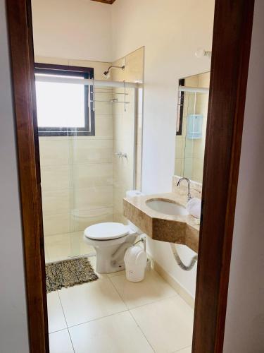 a bathroom with a toilet and a sink and a shower at Mar Egeu Arte & Pouso in Peruíbe