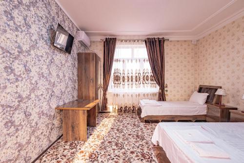 a hotel room with two beds and a window at Major Guest House in Fergana