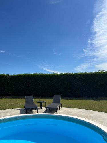two chairs sitting next to a swimming pool at La RonduLina in Tigliole