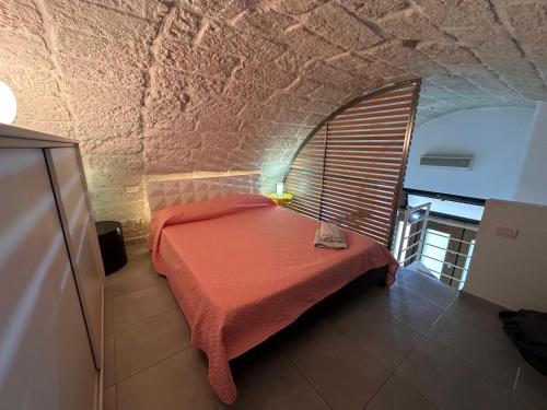 a bedroom with a bed in a brick wall at Nel cuore di Giovinazzo in Giovinazzo
