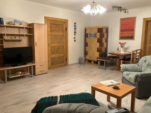 a living room with a couch and a tv and a table at Ferienwohnung "Tier-Garten" in Tribsees