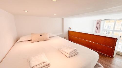 une chambre avec un grand lit blanc avec deux serviettes dans l'établissement Appartement XVIIIème centre historique, à Bordeaux