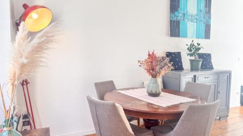 une salle à manger avec une table et des chaises en bois dans l'établissement Appartement XVIIIème centre historique, à Bordeaux