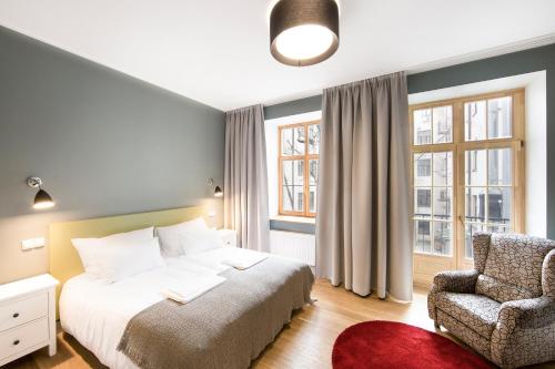 um quarto com uma cama e uma cadeira em Riga Lux Apartments - Skolas em Riga