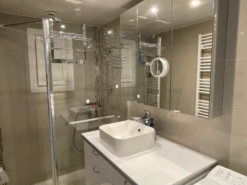 une salle de bain blanche avec un lavabo et une douche dans l'établissement Climatisé, proche Palais des Festivals et des plages, à Cannes