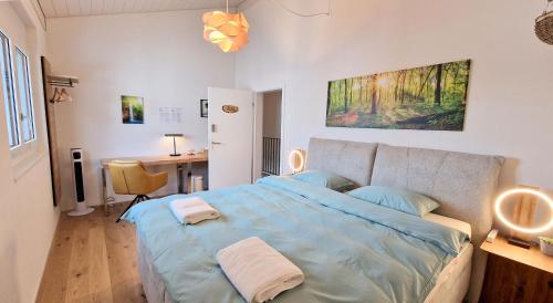 a bedroom with a large bed with a desk and a desk at Mountainside Homestay in Spiez by Menbergs Harmony Homestay in Spiez