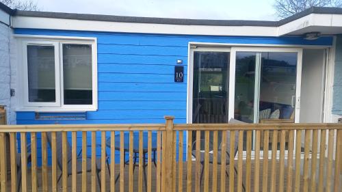 a blue house with a wooden fence in front of it at Chalet Bleu in Sandown