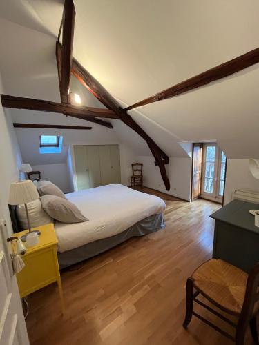 - une chambre avec un lit blanc et du parquet dans l'établissement Appartement douillet, spacieux et convivial, à Vierzon