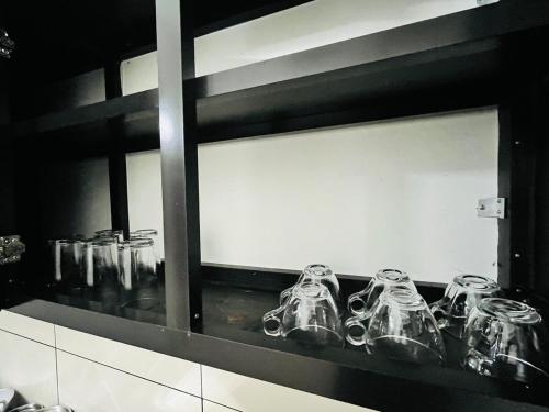 a row of glasses sitting on a shelf at Sunrise Boutique Villa in Kozhikode
