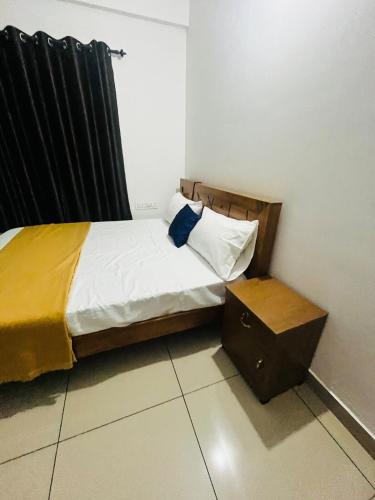 a small bedroom with a bed and a night stand at Sunrise Boutique Villa in Kozhikode