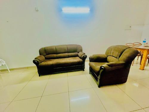 two chairs and a couch in a room at Sunrise Boutique Villa in Kozhikode
