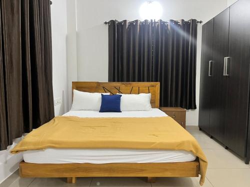 a bedroom with a large bed with a blue pillow at Sunrise Boutique Villa in Kozhikode
