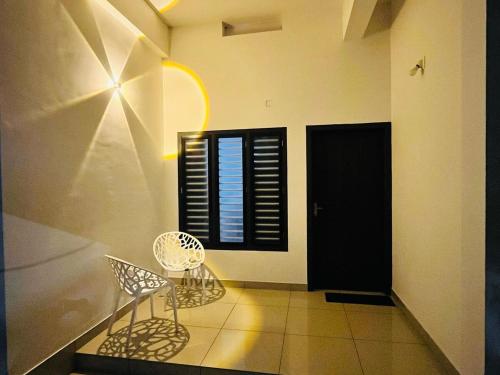 a room with two chairs and a window at Sunrise Boutique Villa in Kozhikode