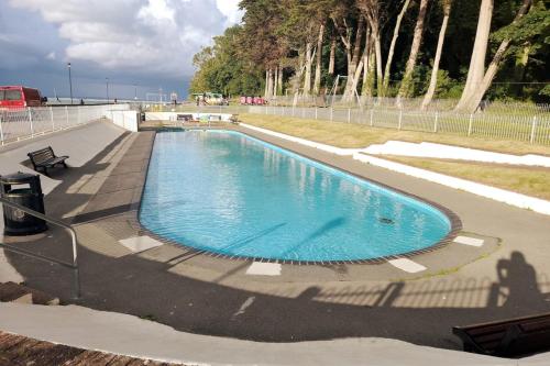 a swimming pool in a park next to a fence at Self Catering Appartment 1 bedroom 2 double beds in East Cowes