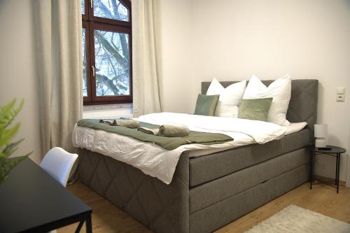 a bedroom with a bed with white and green pillows at GreenTreeHomes - Stadtvilla Linde in Regensburg