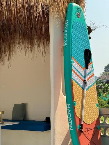 a surfboard hanging on the side of a building at Sunvada Beach Rayong in Rayong