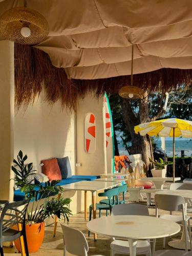 a restaurant with tables and chairs and a large umbrella at Sunvada Beach Rayong in Rayong