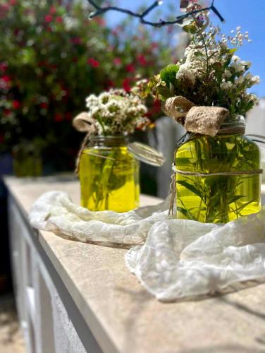 two jars filled with flowers sitting on a table at Masseria Messapia Wine Resort & Spa Salento in Mesagne